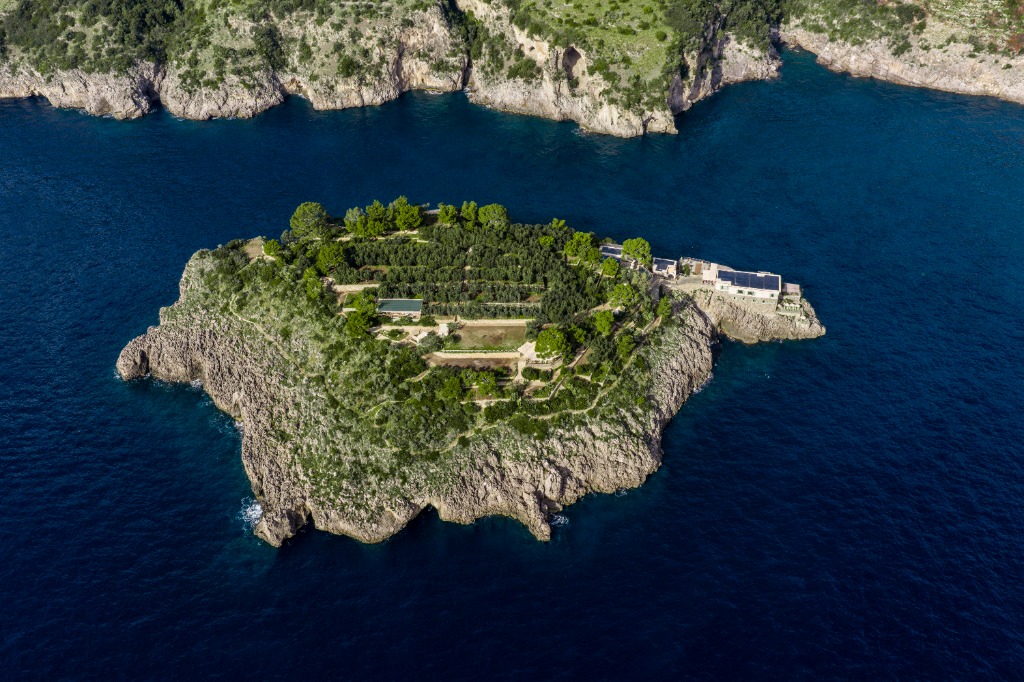 Aerial view of exclusive private island resort with luxury beachfront villas and turquoise lagoon